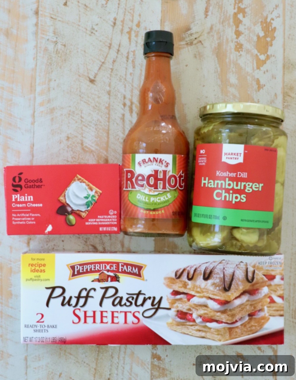 Dill Pickle Pastry Poppers 3 ingredients for puff pastry pickle bites on a white wood board
