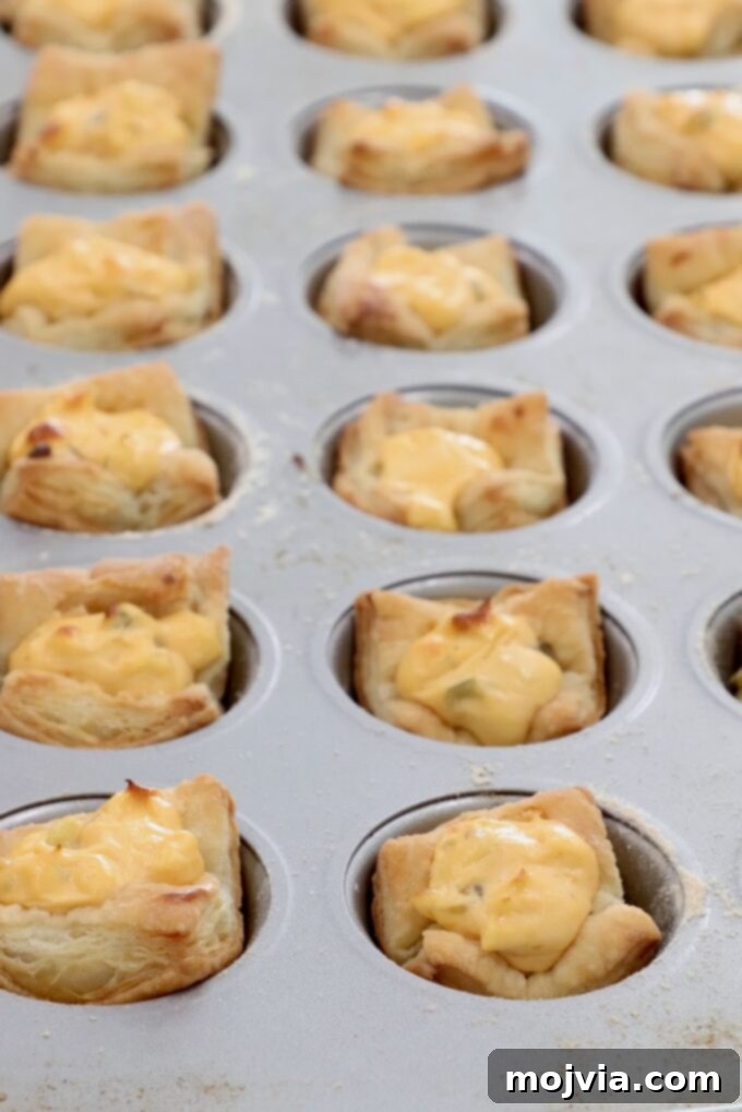 Dill Pickle Pastry Poppers 5 baked puff pastry dough in a mini muffin tin filled with a cream cheese filling
