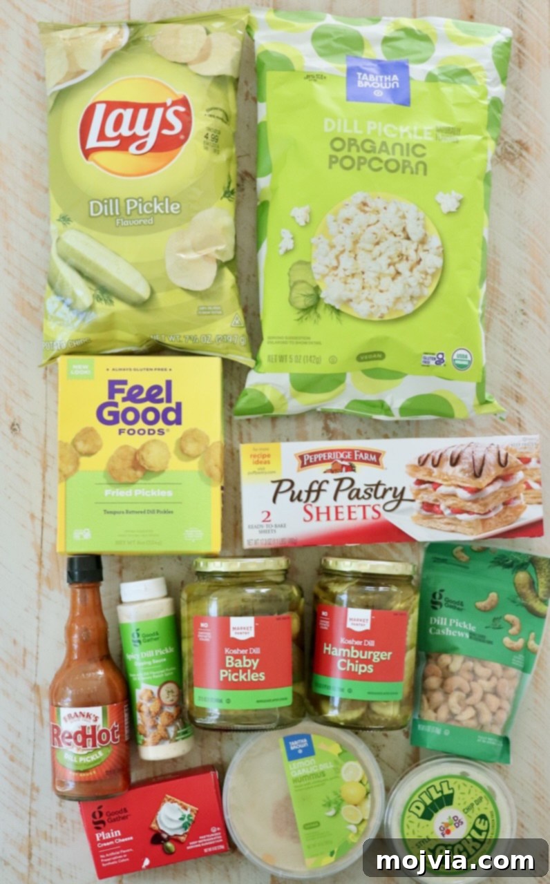 An overhead view of a beautifully arranged white wooden board showcasing an array of pickle-flavored snacks, including various dips, crispy chips, and nuts.