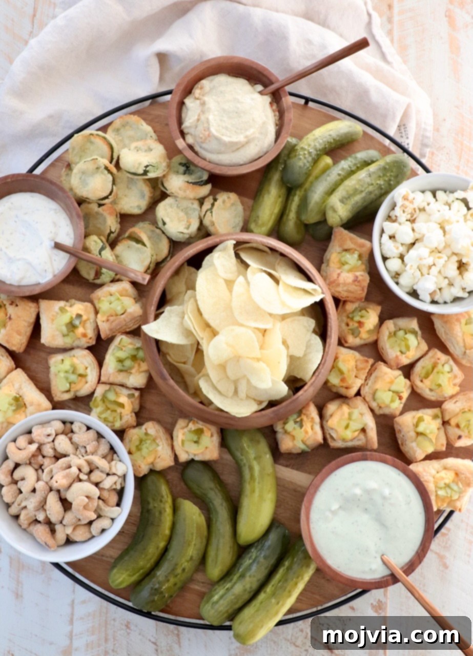 A large, rustic wooden charcuterie board creatively arranged with a variety of dill pickles, creamy dips, and crunchy pickle-flavored snacks.
