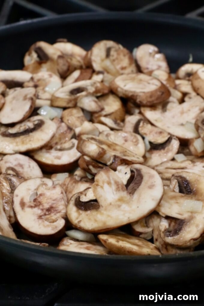 Wild Mushroom Gravy 4 Sliced mushrooms being sautéed in a large skillet until tender and browned.
