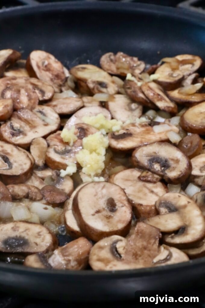Wild Mushroom Gravy 5 Minced garlic added to the sautéed mushrooms and onions in the skillet, cooking to release its aroma.