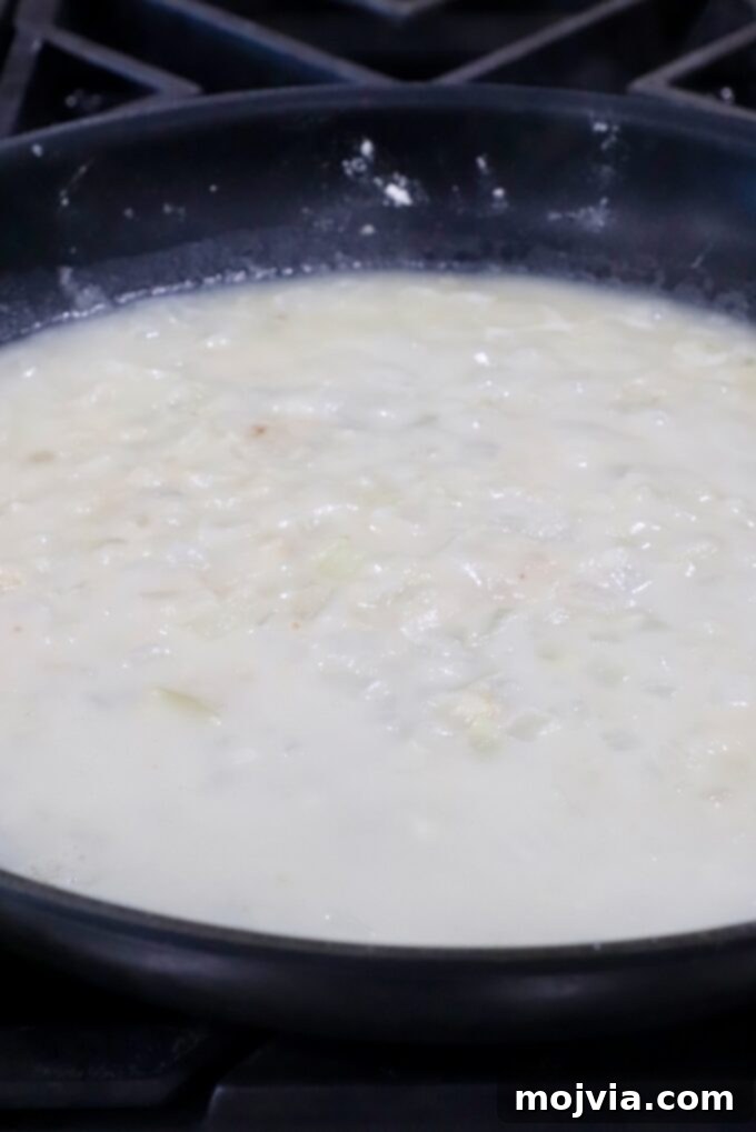 Ultimate Cheesy Potato Bake 6 diced onions and garlic in a skillet with flour and broth