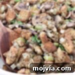 Umami Mushroom Stuffing 12 Mushroom Stuffing in a baking dish with a serving spoon, enticingly golden brown.