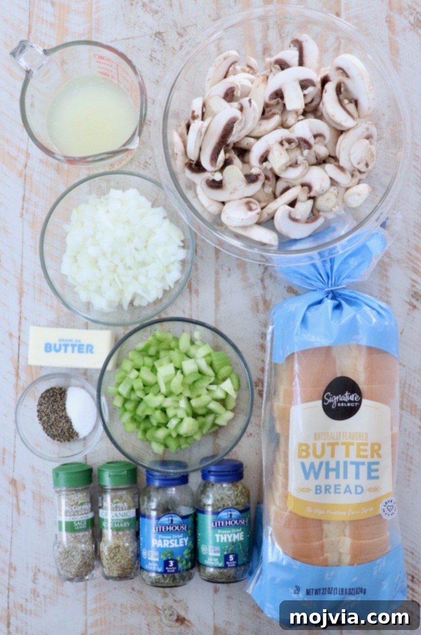 Umami Mushroom Stuffing 3 Fresh ingredients for mushroom stuffing laid out on a rustic white wooden board, including sliced mushrooms, celery, onions, butter, and various dried herbs.