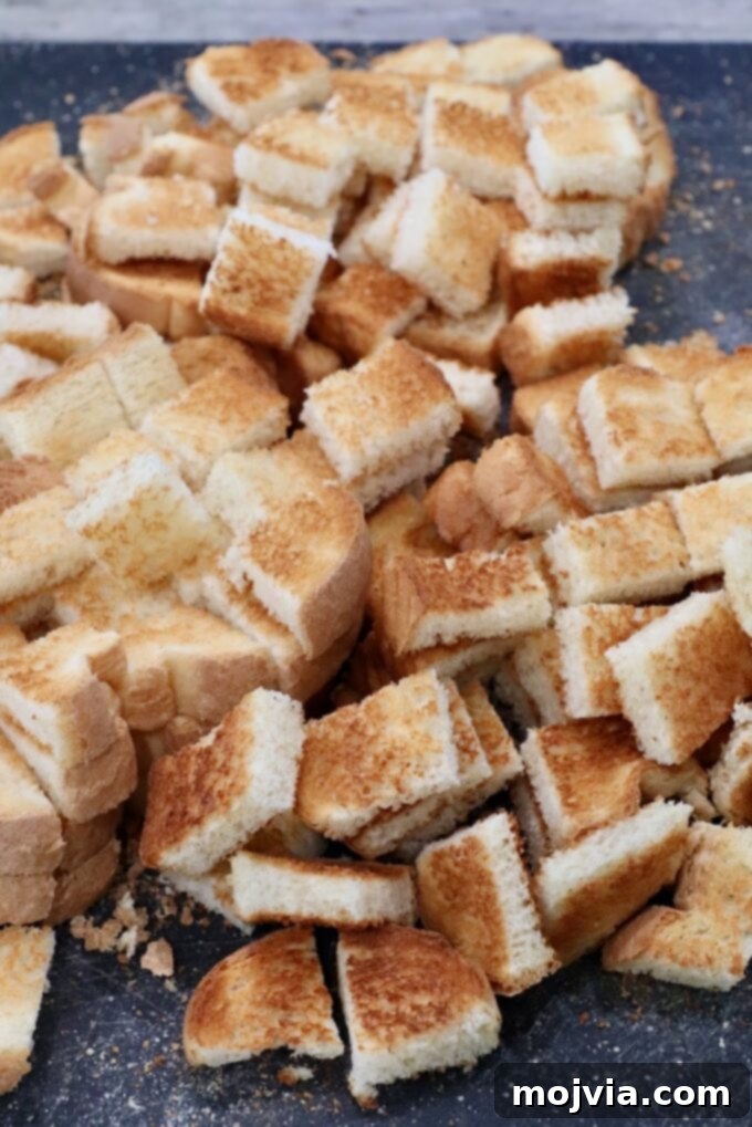 Umami Mushroom Stuffing 4 Crispy toasted bread cubes neatly arranged on a wooden cutting board, ready for the next step of stuffing preparation.