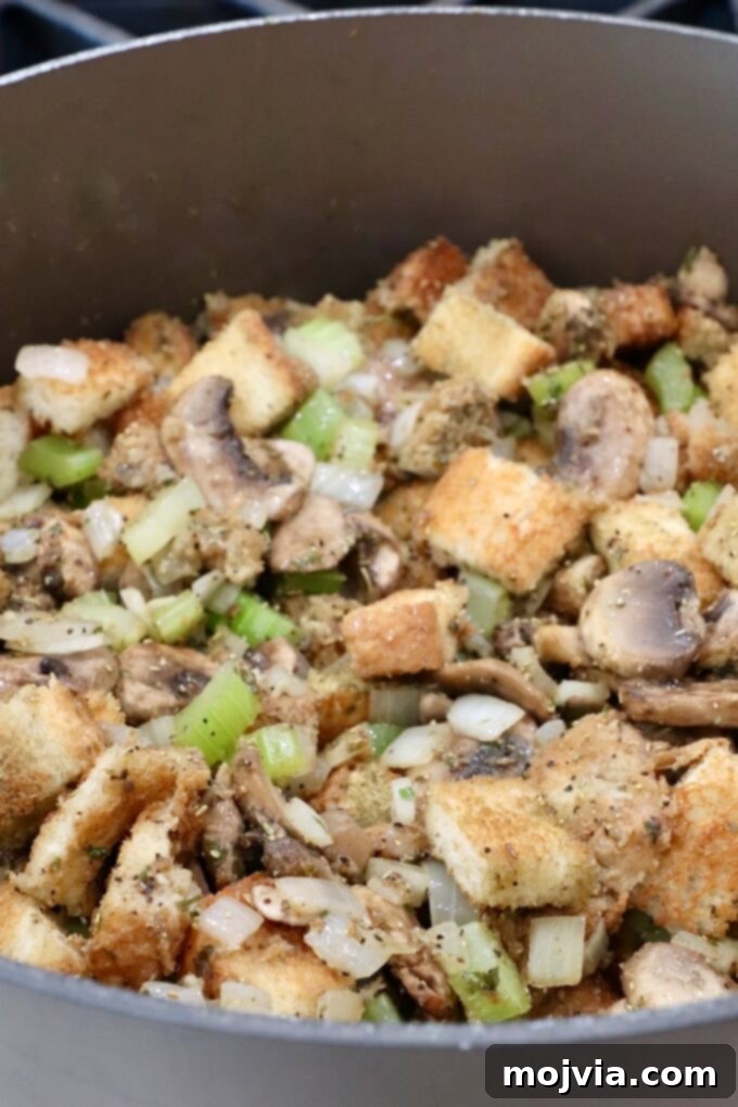 Umami Mushroom Stuffing 8 The fully mixed mushroom stuffing, moistened with chicken broth, in a large pot, showing a perfect balance of texture and moisture.