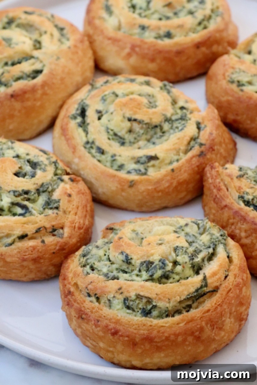 Savory Spinach Swirls 8 Baked spinach pinwheels presented beautifully on a white plate, ready to be served as an appetizer