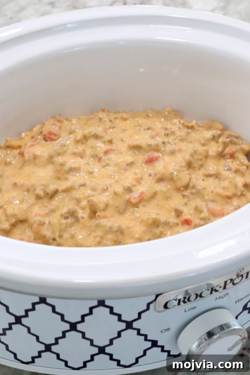 Irresistible Party Queso 5 velvetta rotel dip in a small crock pot