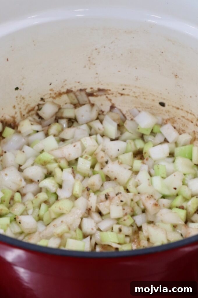 Diced onions and celery cooking in a Dutch oven to build flavor