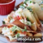 Asian Chicken Wonton Tacos 10 Close-up of a perfectly assembled chicken wonton taco, showcasing the crispy shell, sweet chili chicken, and fresh coleslaw