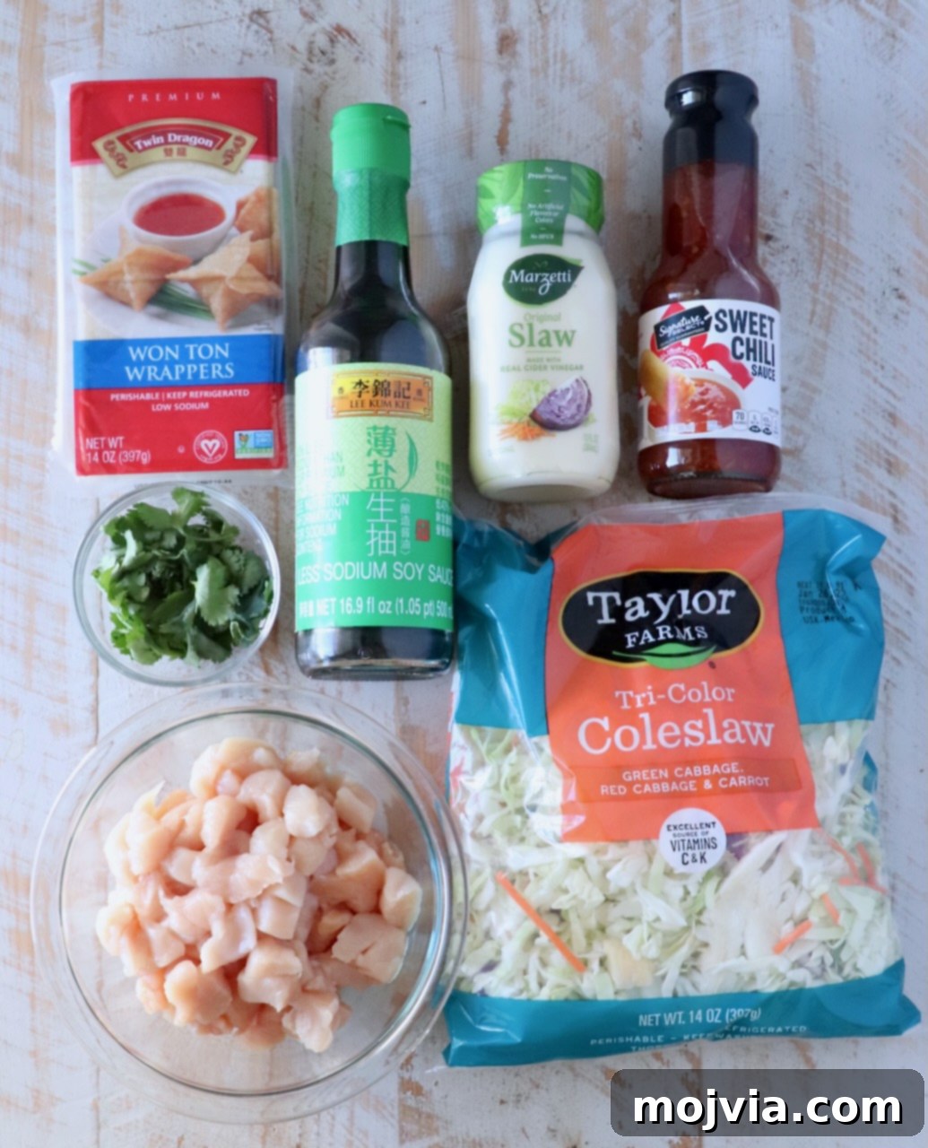 Asian Chicken Wonton Tacos 3 Essential ingredients for homemade chicken wonton tacos laid out on a white wooden board, ready for preparation