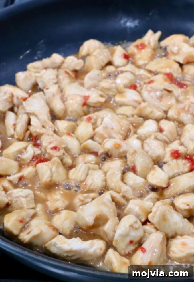 Asian Chicken Wonton Tacos 8 Sweet chili chicken cooking in a hot skillet, stirring occasionally for even browning and perfect tenderness