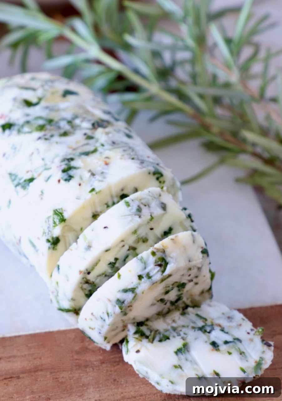 Butter Infusions 2 sliced compound butter on a cutting board with fresh rosemary on the side