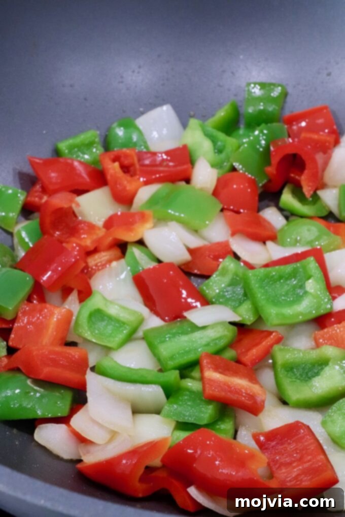cooked diced bell peppers and onions in a large wok