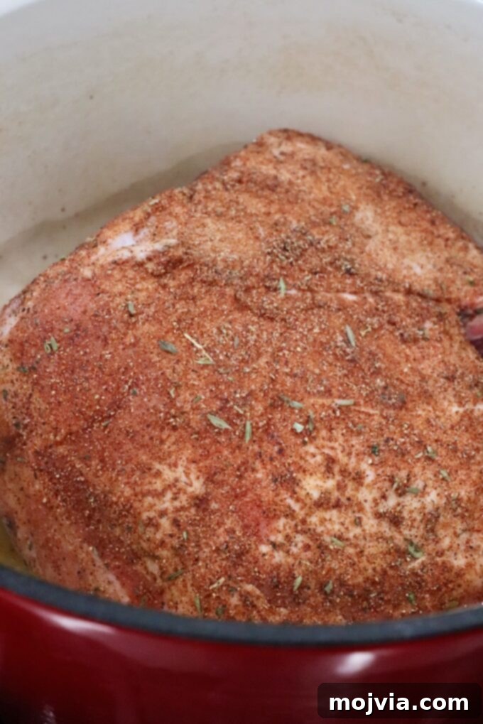 seasoned pork shoulder in a large cast iron pot