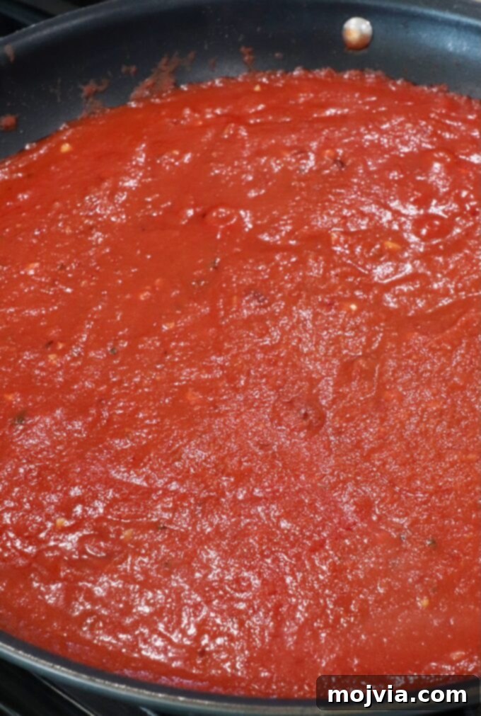 Fiery Nduja Tomato Sauce 7 The finished nduja tomato sauce, perfectly emulsified and rich in color, simmering gently in a skillet