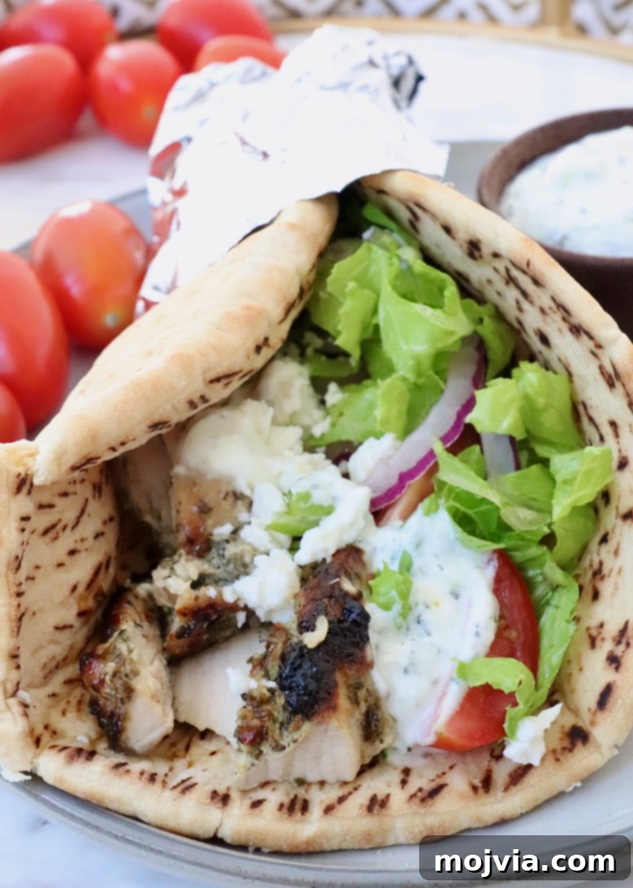 Greek Style Chicken Gyros 2 cooked chicken gyro meat in a piece of pita bread with lettuce, tomato and tzatziki sauce