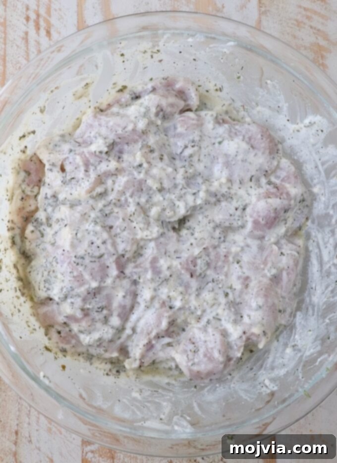 Greek Style Chicken Gyros 4 chicken thighs in a seasoned yogurt marinade in a large glass bowl