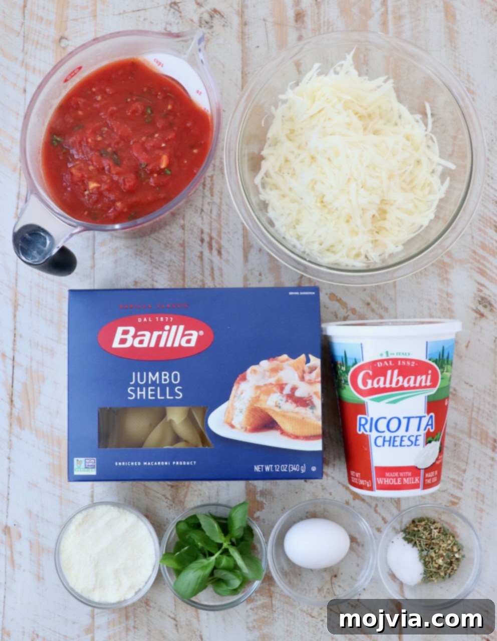Cheesy Baked Stuffed Shells 3 ingredients for stuffed shells on a white wood board