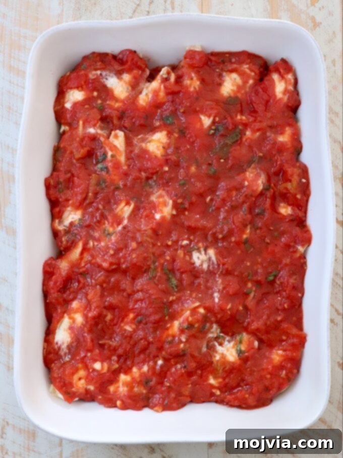 Cheesy Baked Stuffed Shells 8 stuffed shells topped with marinara sauce in a casserole dish