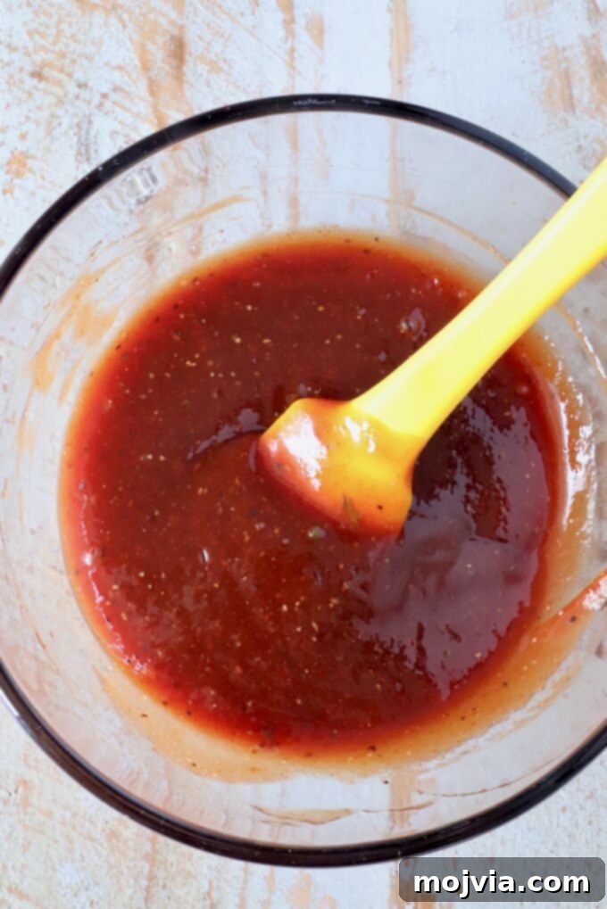 Perfect Air Fryer Meatloaf 7 meatloaf glaze in a glass bowl with a yellow spatula