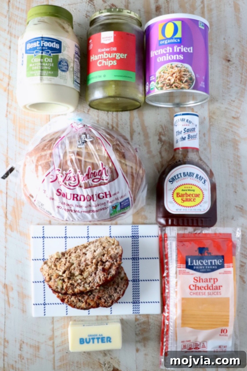 ingredients for meatloaf sandwich on a white wood board