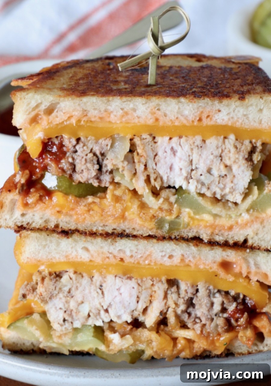 meatloaf sandwich sliced in half and stacked up on top of each other on a plate with a wooden skewer stuck in the top of the sandwich