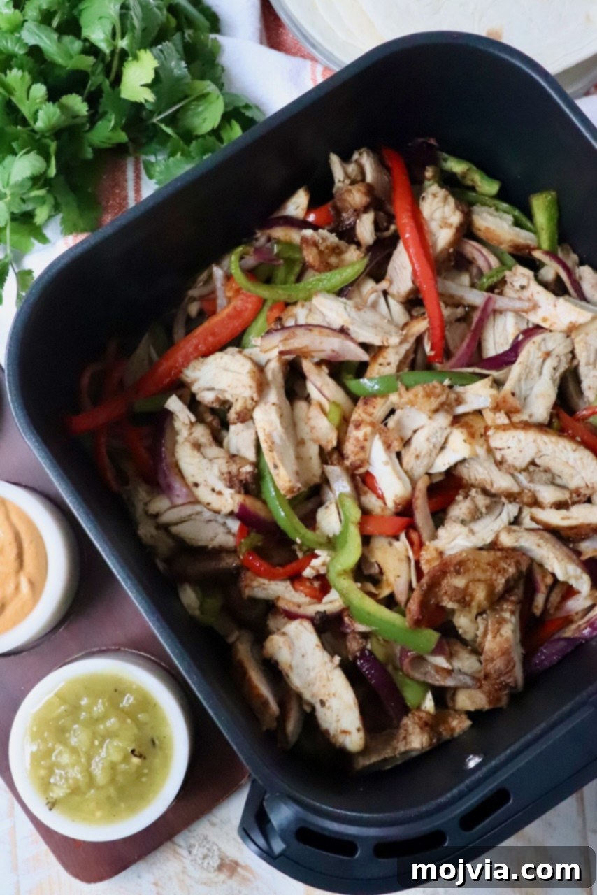 Sizzling Air Fryer Chicken Fajitas 2 Sizzling air fryer chicken fajitas with perfectly cooked chicken strips, colorful bell peppers, and tender onions, ready to be served.