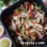 Sizzling Air Fryer Chicken Fajitas 11 cooked, sliced fajita chicken thighs and vegetables in an air fryer basket