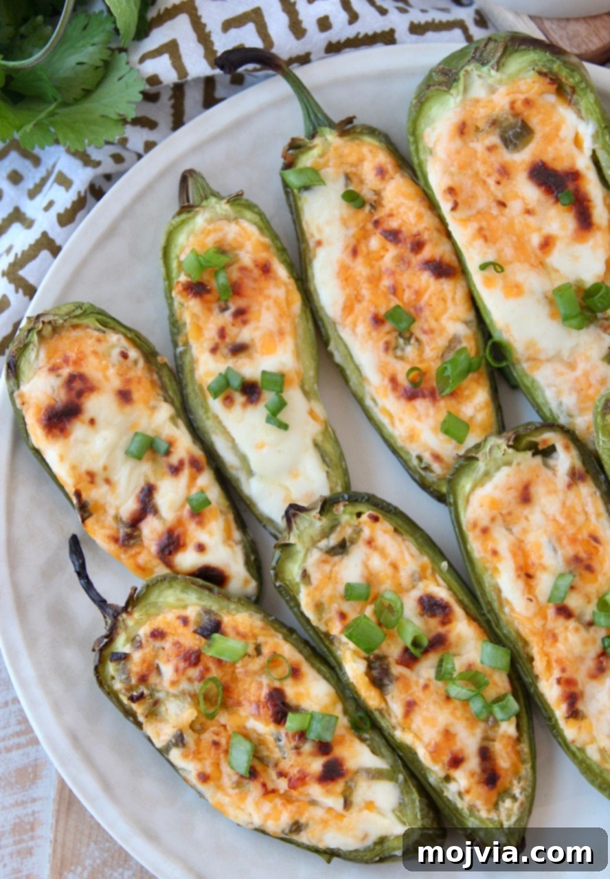 Smoky Cheesy Jalapeño Bites 7 Cooked jalapeno poppers elegantly arranged on a serving plate.