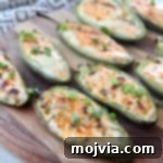Grilled jalapeno poppers arranged on a wooden cutting board, ready to serve.