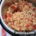 Cooked Mexican rice in an Instant Pot with a large serving spoon