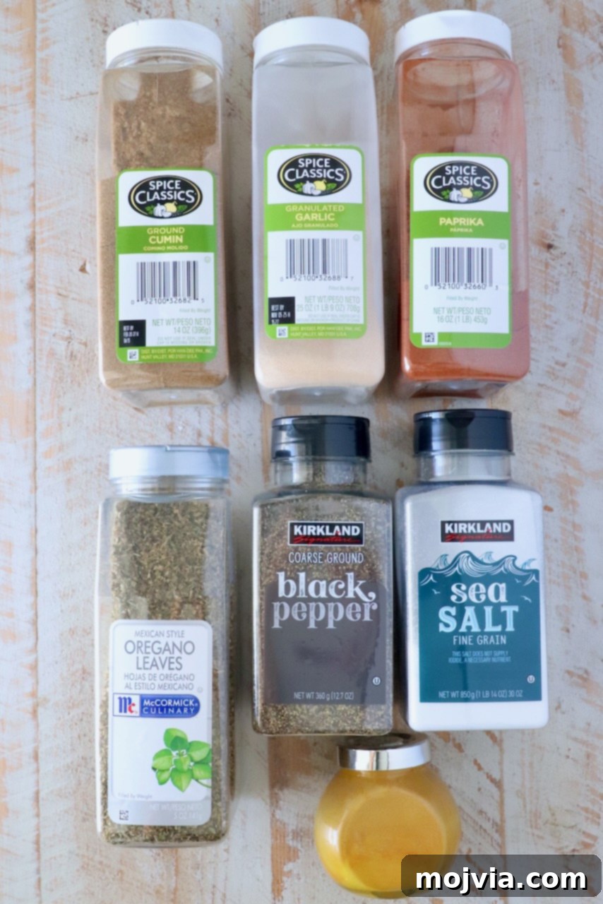 Adobo Spice Blend 3 containers of various dried herbs and spices lined up on a white wood board, ready to be mixed into Adobo seasoning