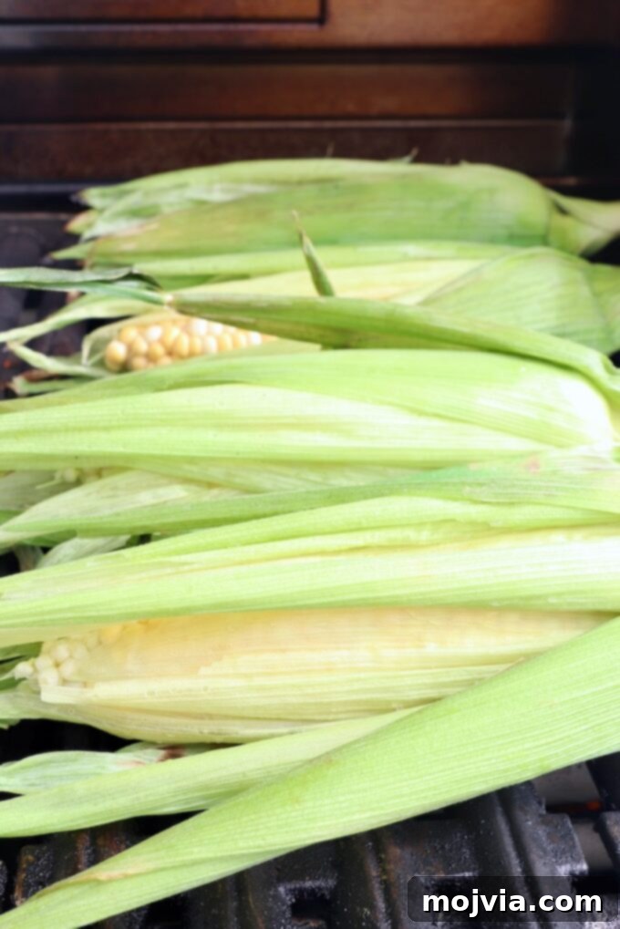 Esquites Style Corn Salad 4 corn on the cob in husks on the grill
