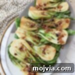 Petite Bok Choy 7 cooked baby bok choy on a plate covered in garlic shallot soy sauce