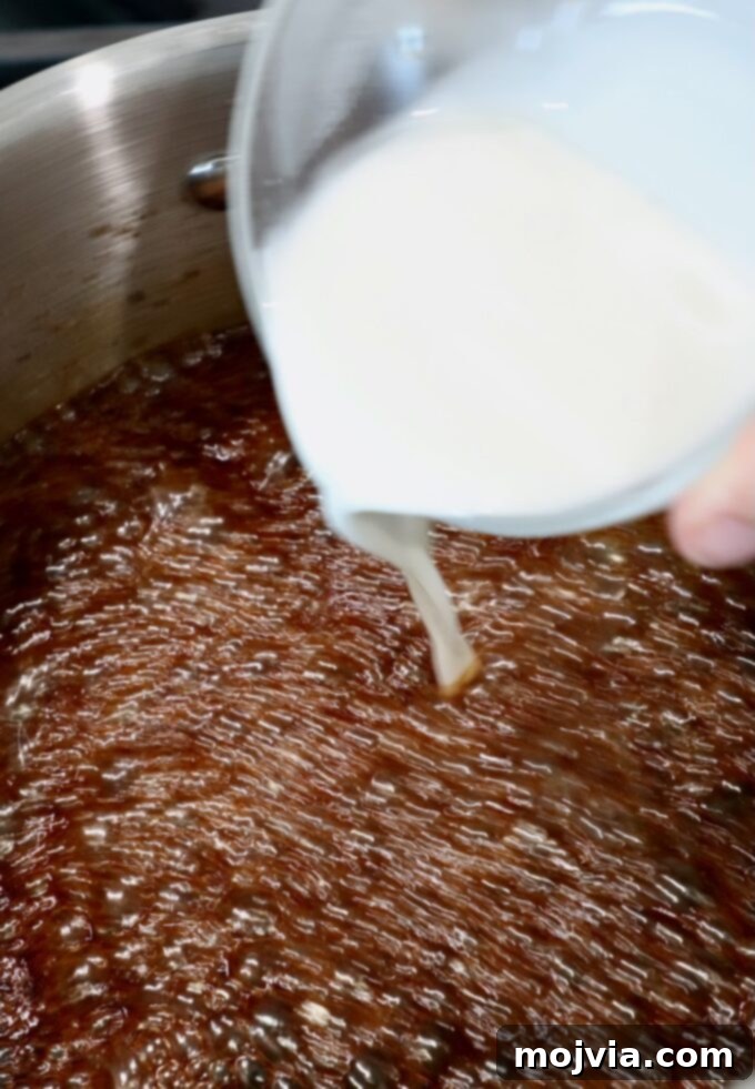 Authentic Korean BBQ Sauce 5 A cornstarch slurry being carefully poured from a small glass bowl into the bubbling Korean BBQ sauce in a pot, to achieve the perfect thickness.
