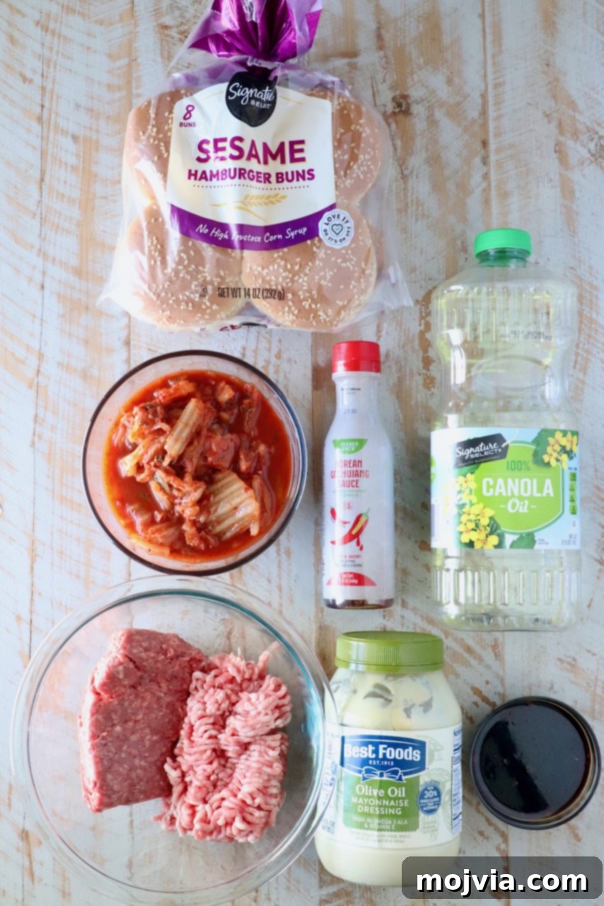 A selection of fresh ingredients for Korean BBQ Burgers arranged on a rustic white wooden board