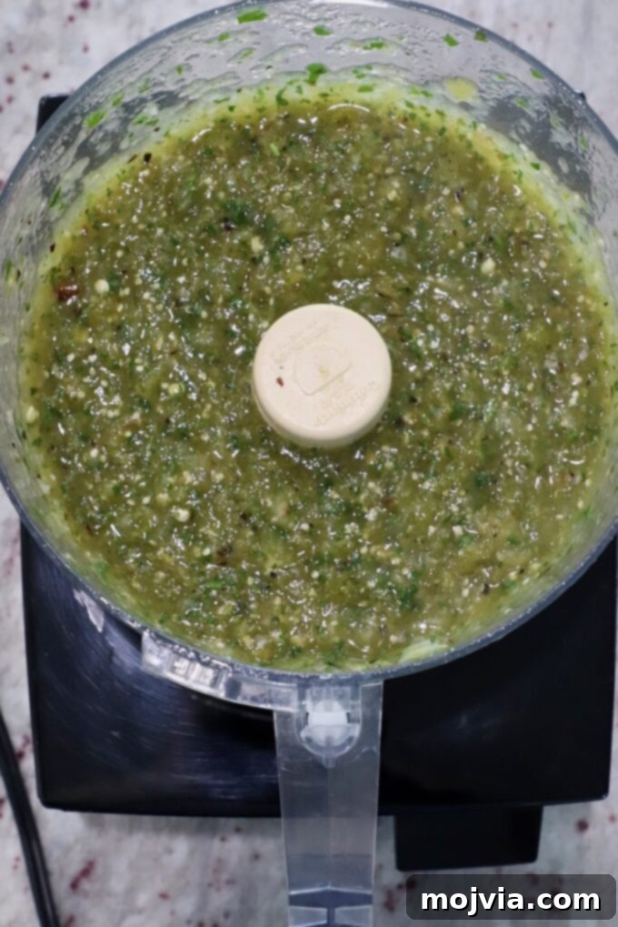 Verde Zing Salsa 7 Blended green salsa verde in a food processor, showing a perfectly chunky consistency after pulsing.