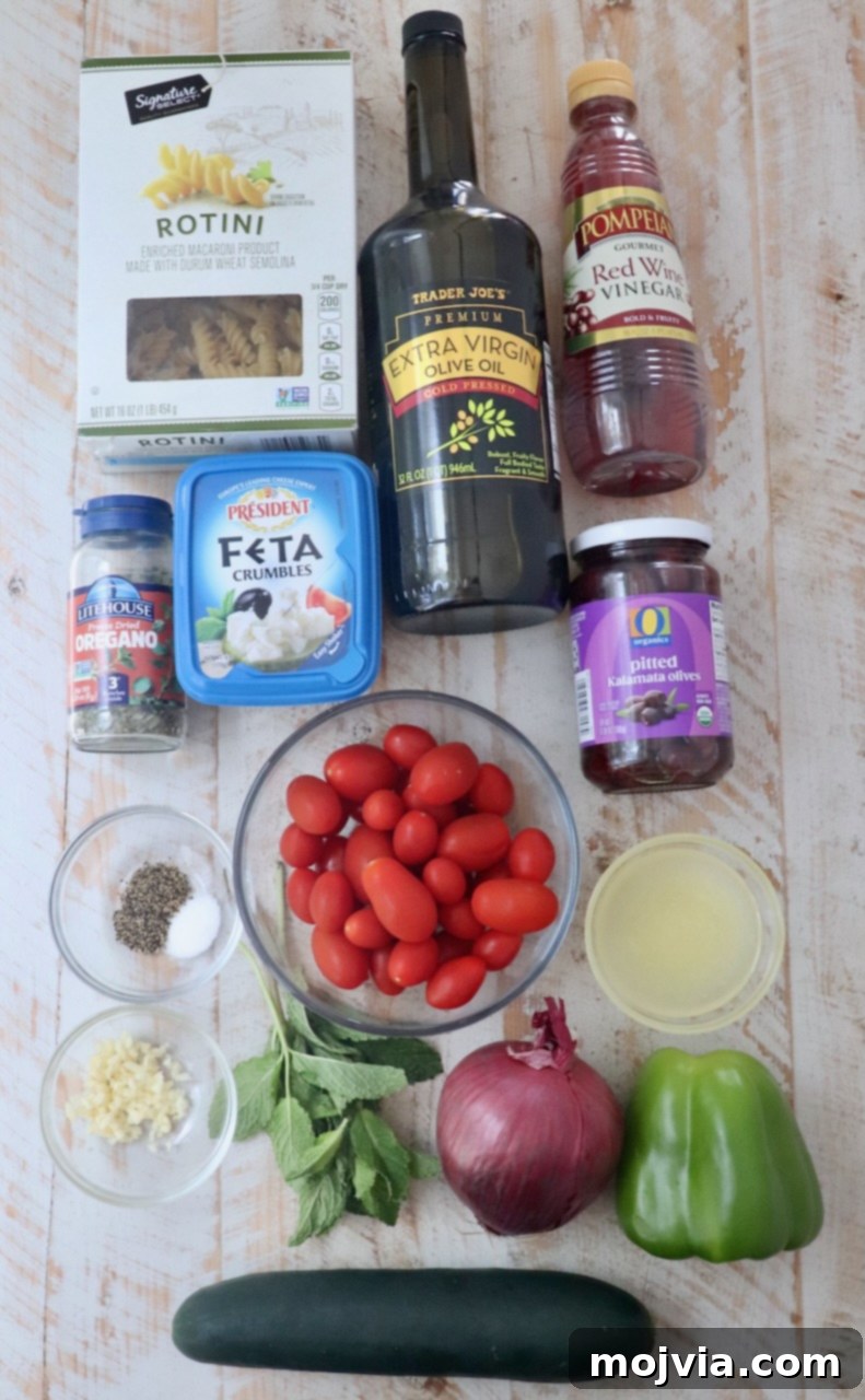 Aegean Breeze Pasta Medley 3 ingredients for Greek pasta salad on a white wood board