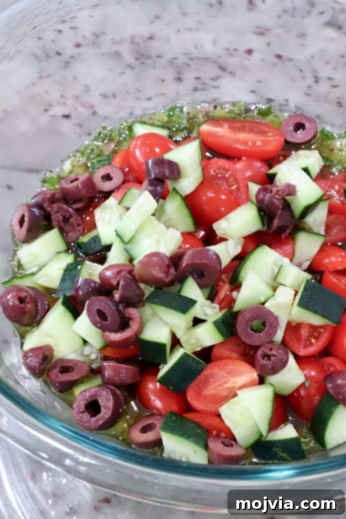 Aegean Breeze Pasta Medley 6 diced cucumber, tomatoes and olives in a large glass bowl