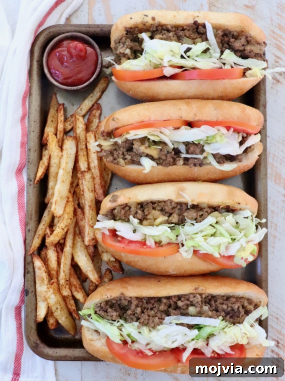 The Ultimate Chopped Cheese 2 Four perfectly assembled chopped cheese sandwiches with fresh fries and a small bowl of ketchup