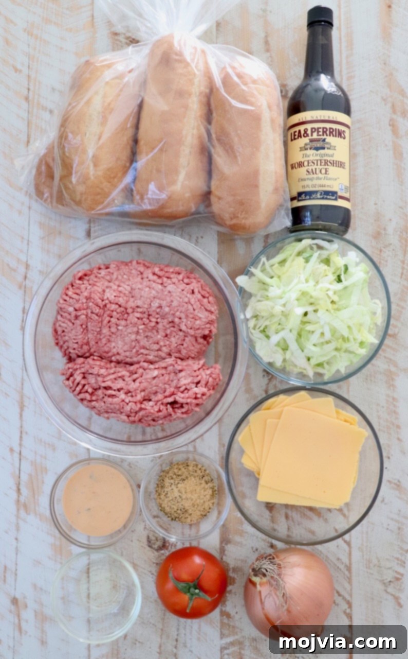 The Ultimate Chopped Cheese 3 Fresh ingredients for a homemade chopped cheese sandwich arranged on a white wooden board