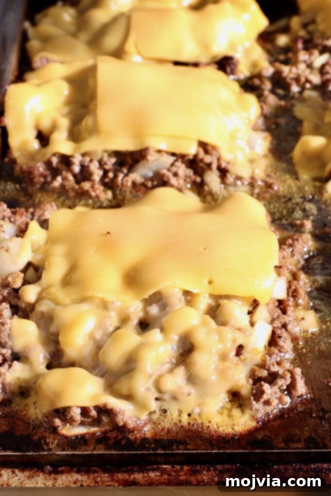 The Ultimate Chopped Cheese 6 Ground beef mixture topped with slices of American cheese melting on a griddle