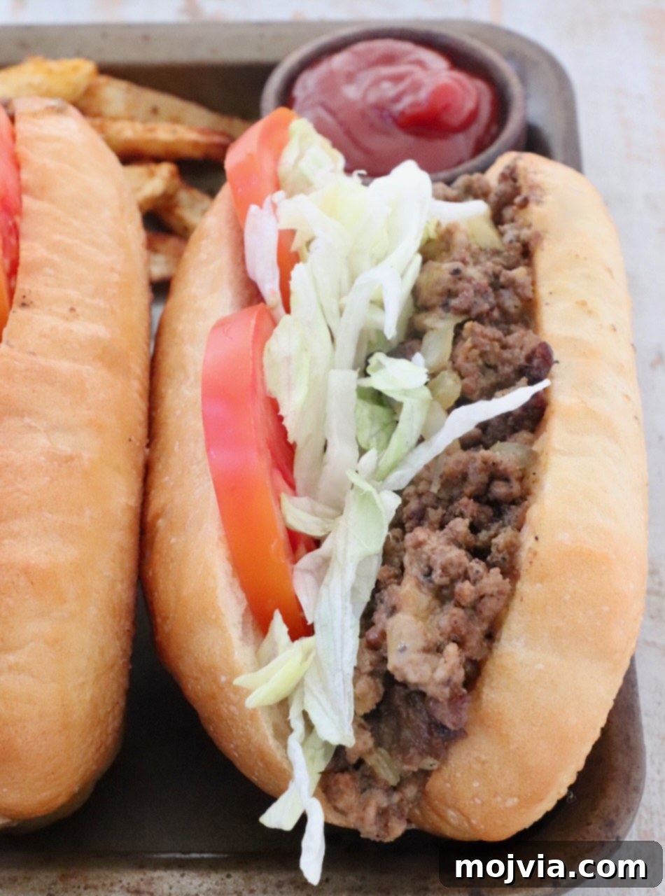 The Ultimate Chopped Cheese 8 A single chopped cheese sandwich artfully placed on a metal baking sheet with a small bowl of ketchup in the background