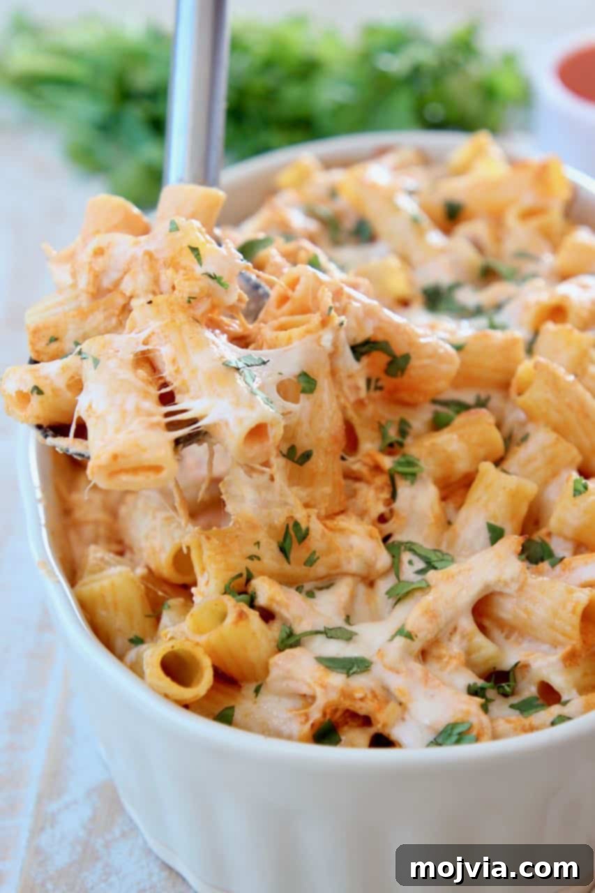 Spicy Buffalo Chicken Pasta Bake 3 Baked cheesy pasta with spoonful coming out of baking dish