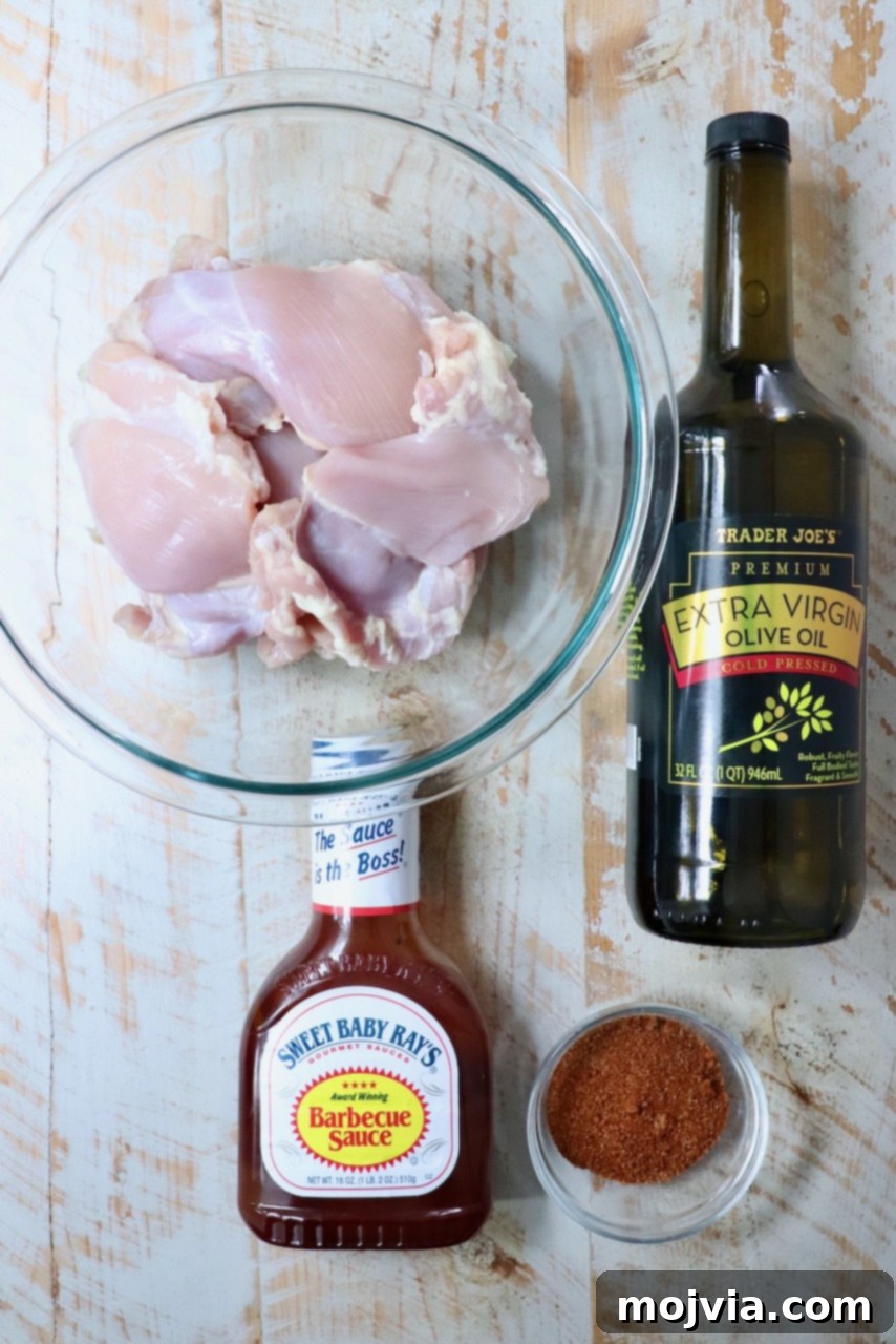 Perfectly Smoked Chicken Thighs 3 ingredients for smoked chicken thighs on a white wood board