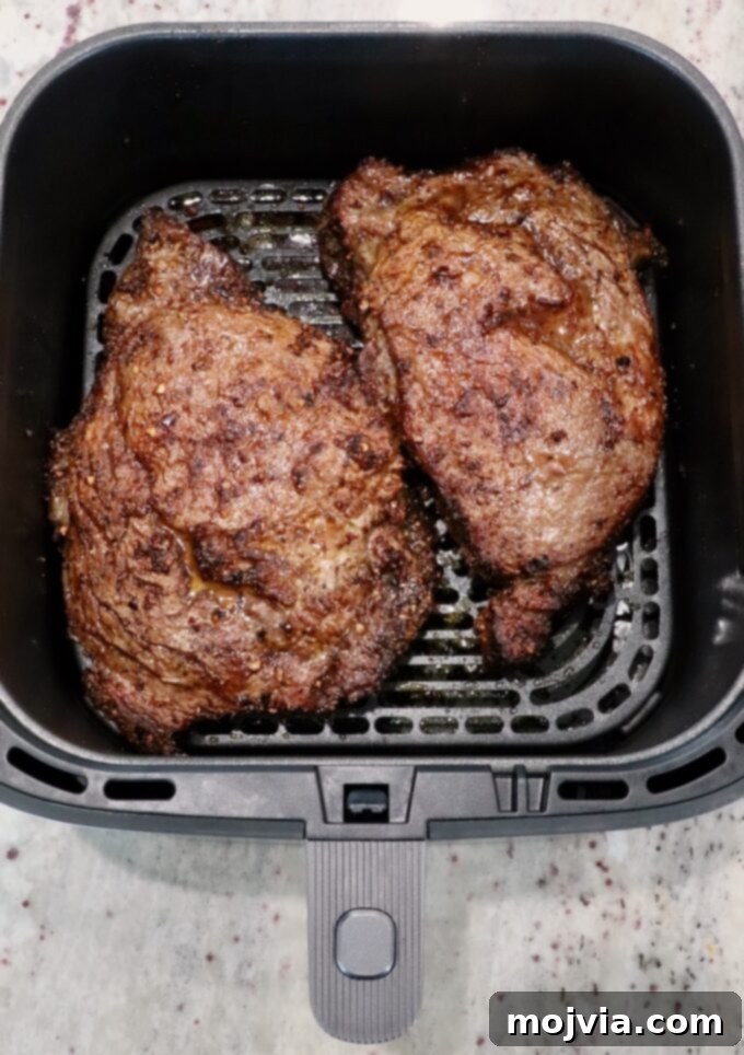 Air Fryer Steakhouse Steak 7 cooked ribeye steaks in an air fryer basket