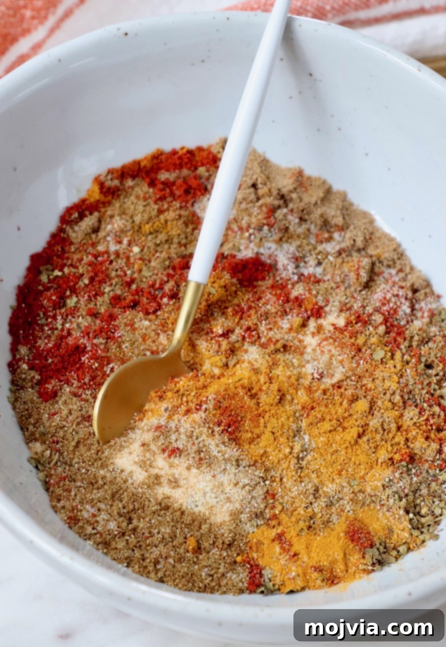 Sazon Spice Blend 2 spices mixed together in a bowl with a small spoon