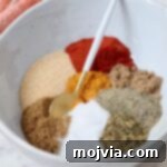 Sazon Spice Blend 6 spices separated in a bowl with a spoon